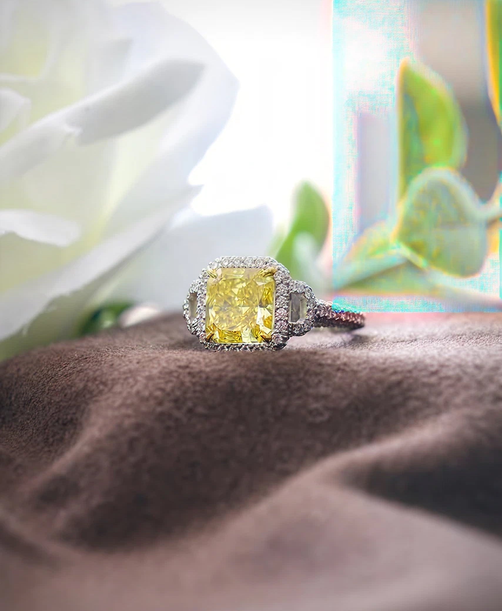 Luxury yellow diamond ring with silver setting on a textured surface